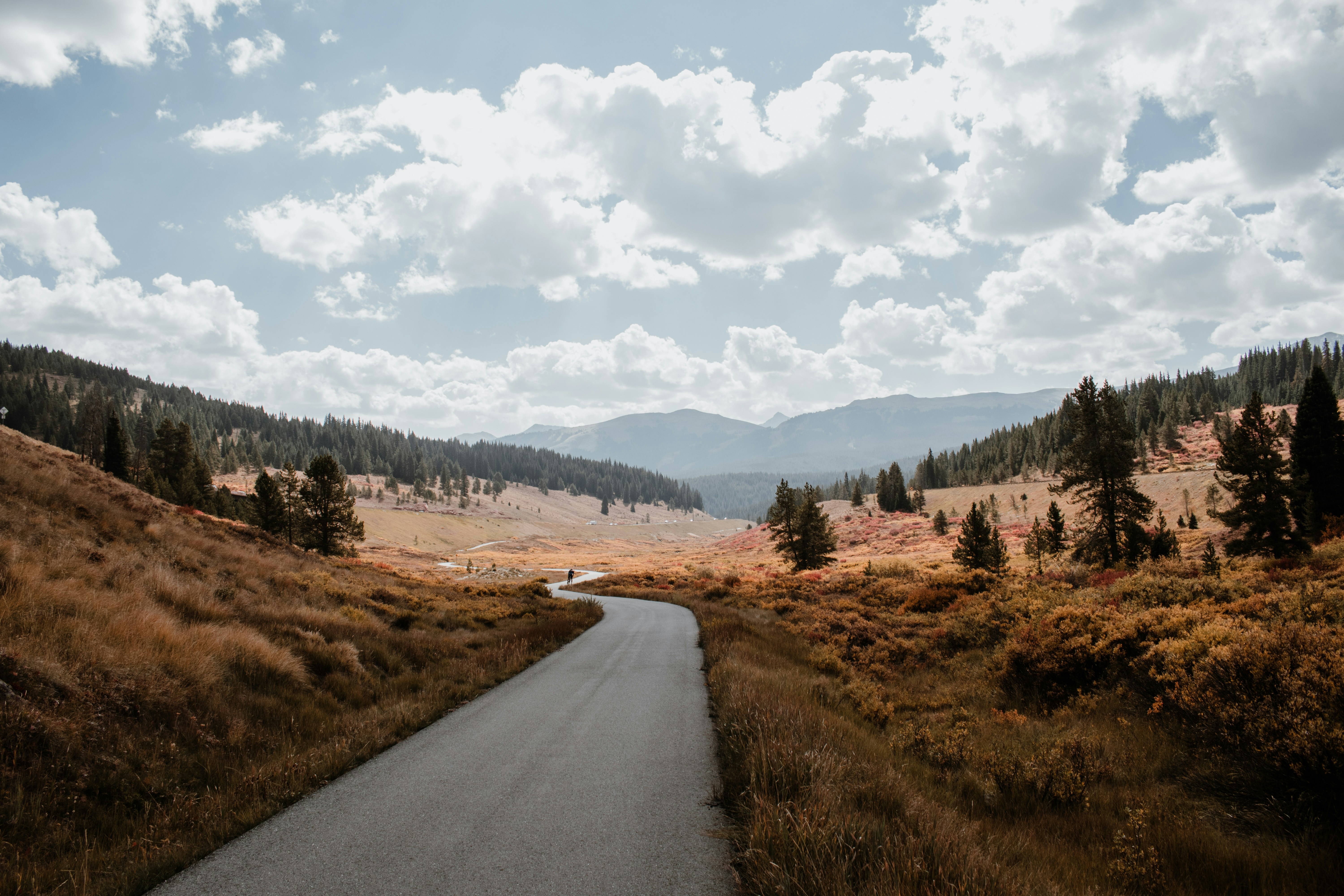 Winding road through a mountain valley under a cloudy sky